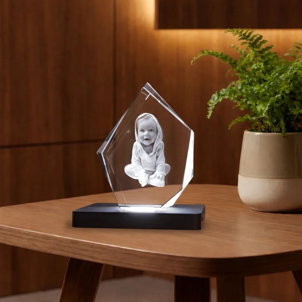 Photo d'un bébé gravée dans un bloc de verre cristal lumineux sur socle noir.
