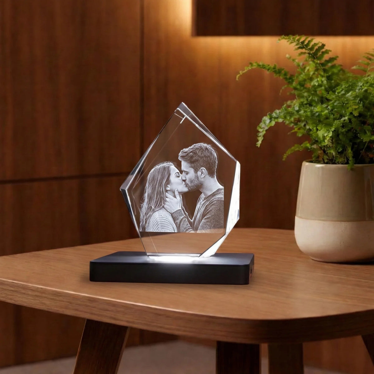 Photo gravée dans un bloc de verre cristallin en forme de diamant sur socle lumineux.