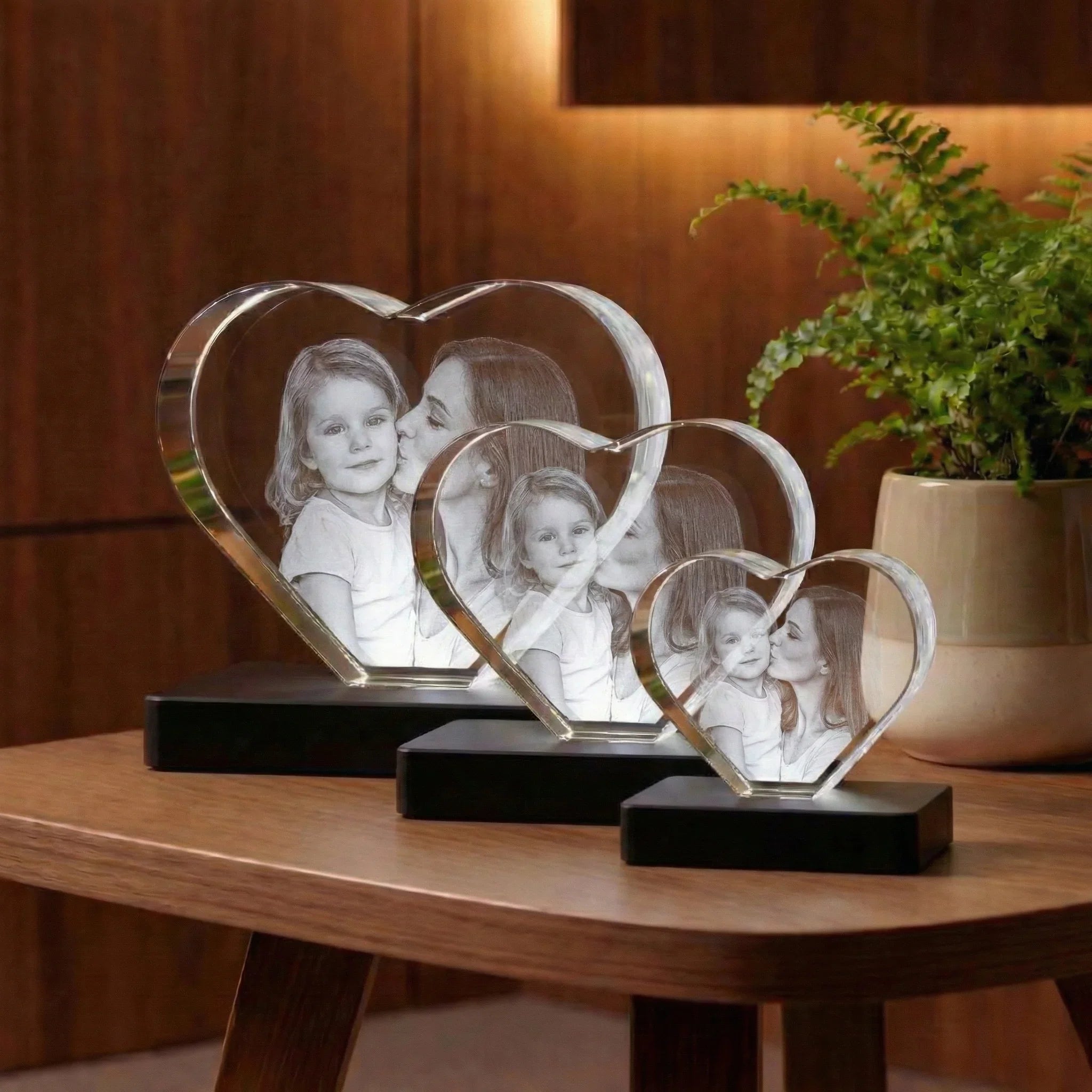 Cœurs en verre personnalisés avec photo gravée, posés sur une table en bois