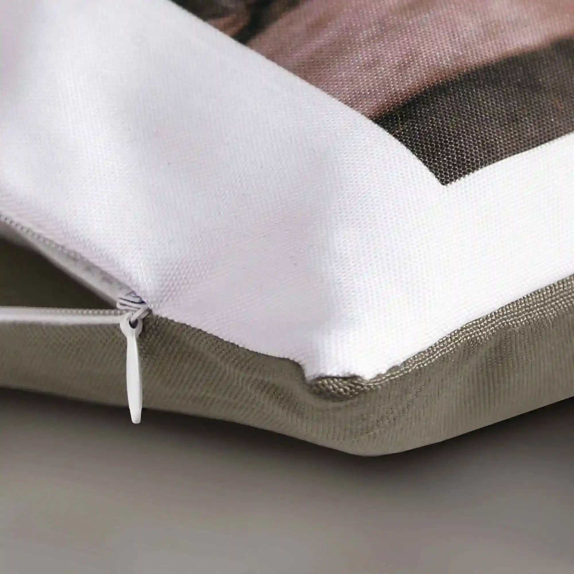 Gros plan sur coin de coussin personnalisé avec fermeture éclair, tissu beige et blanc