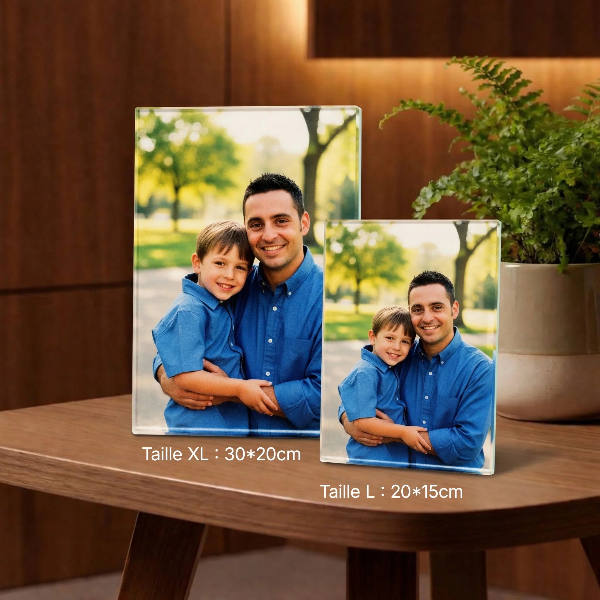 Deux cadres photo en verre personnalisés avec image d’un père et fils, tailles 30x20cm et 20x15cm, posés sur une table en bois. Décor moderne avec plante.