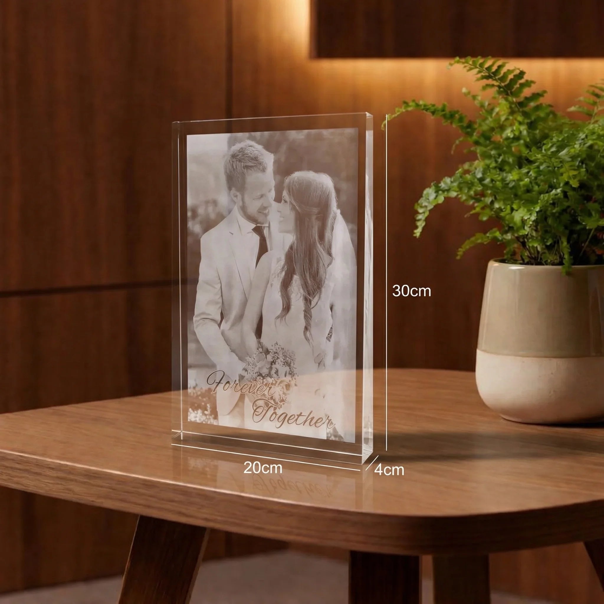 Bloc en verre gravé avec photo de marié, posé sur une table en bois, décoration chaleureuse