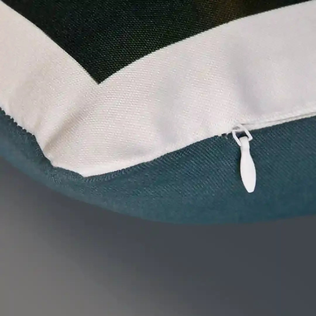 Gros plan sur un coussin bleu canard avec fermeture éclair blanche visible