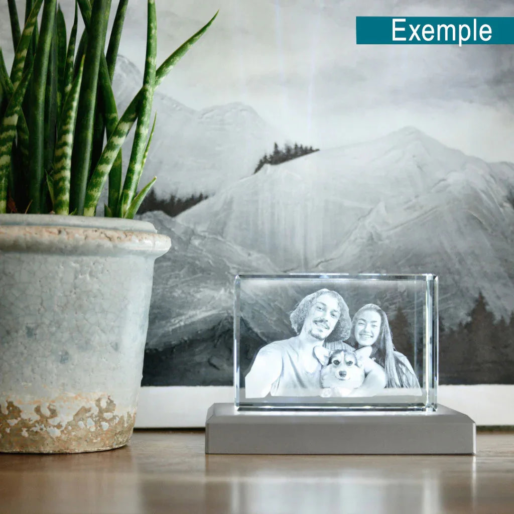 Photo gravée dans un bloc de verre personnalisable, posée sur une table près d'une plante