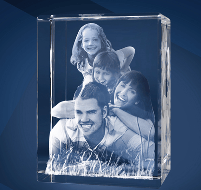 Bloc de Verre Géant Portrait - Gravure Laser 3D d'un couple avec deux enfants allongés dans l'herbe.